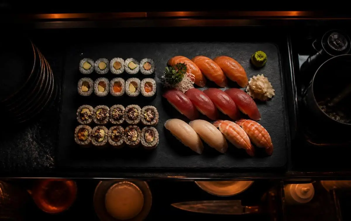 Plateau de makis et de nigiris dressé sur une ardoise au passe d'un restaurant